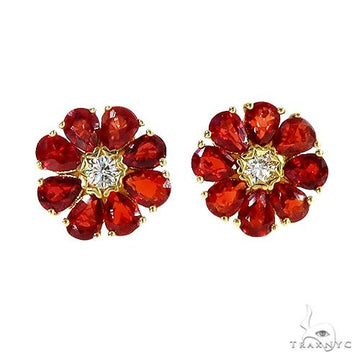 Pear-shaped red sapphire flower cluster earrings with central white gemstone and yellow gold setting.