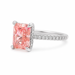White gold engagement ring featuring a radiant-cut pink lab grown diamond, pavé diamond band, and diamond hidden halo.