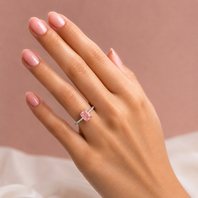 White gold engagement ring featuring a radiant-cut pink lab grown diamond, pavé diamond band, and diamond hidden halo.
