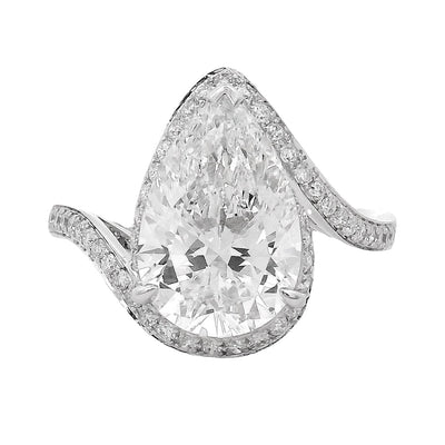 Pear-shaped diamond engagement ring with pavé diamond band in white gold.