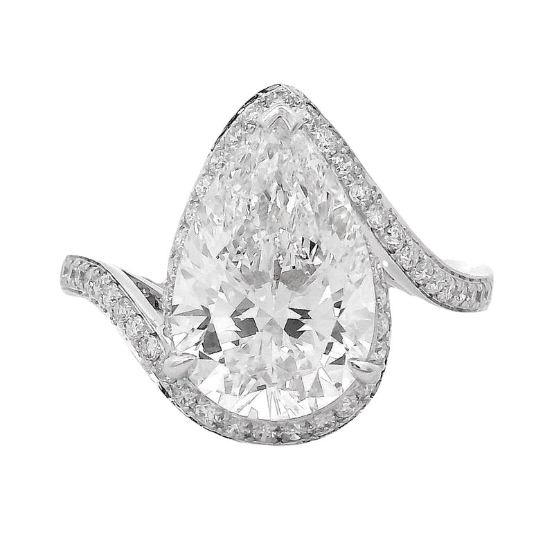 Pear-shaped diamond engagement ring with pavé diamond band in white gold.
