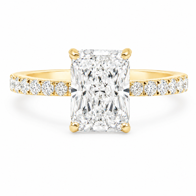 Yellow gold engagement ring with radiant-cut diamond and small side diamonds on a tapered band.