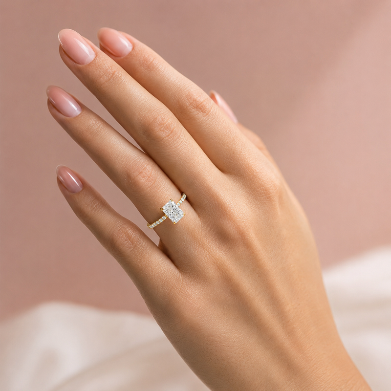 Yellow gold engagement ring with radiant-cut diamond and small side diamonds on a tapered band.