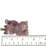 Cat figurine encrusted with multicolored sapphire crystals, raised paw design.