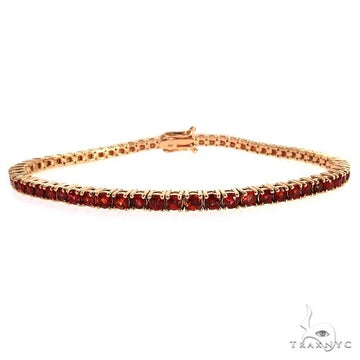 Rose gold tennis bracelet with vibrant red sapphire gemstones, sleek and elegant design.