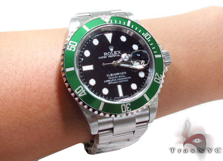 Rolex Submariner 16610 steel watch with black dial and green bezel, stainless steel bracelet.