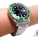 Rolex Submariner 16610 steel watch with black dial and green bezel, stainless steel bracelet.