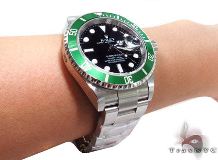 Rolex Submariner 16610 steel watch with black dial and green bezel, stainless steel bracelet.