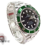 Rolex Submariner 16610 steel watch with black dial and green bezel, stainless steel bracelet.