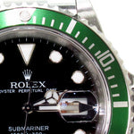 Rolex Submariner 16610 steel watch with black dial and green bezel, stainless steel bracelet.
