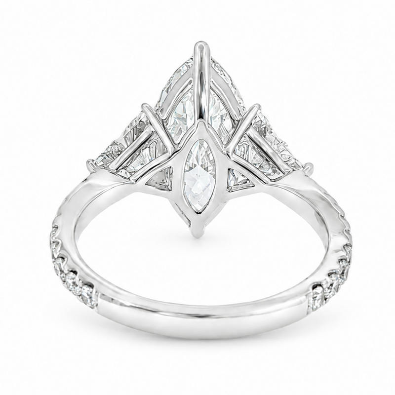 Marquise-cut lab-grown diamond three-stone engagement ring with trillion side stones and pavé diamond band.
