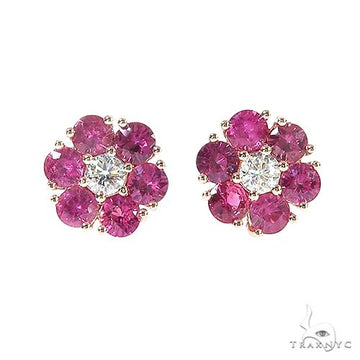 Ruby flower cluster earrings with central white gemstone and round ruby petals in gold setting.