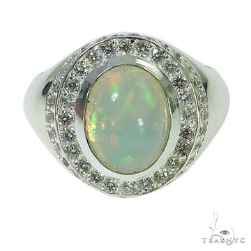 Silver ring with oval opal center stone and sparkling clear gemstone halo.