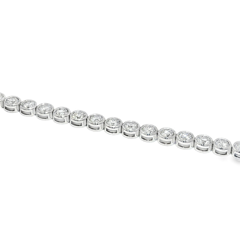 White gold bezel set tennis bracelet with round diamonds and secure clasp.