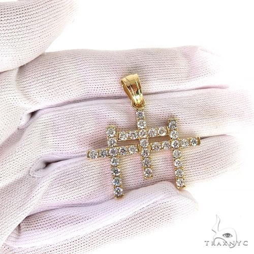 Yellow gold triple cross pendant encrusted with round diamonds, held by white glove