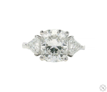 Three-stone cushion cut diamond engagement ring – cushion center stone with side diamond accents, front-facing view