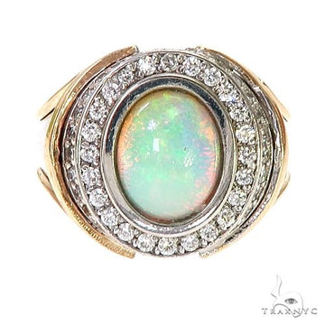 Two-tone gold ring with oval opal center surrounded by sparkling diamonds.