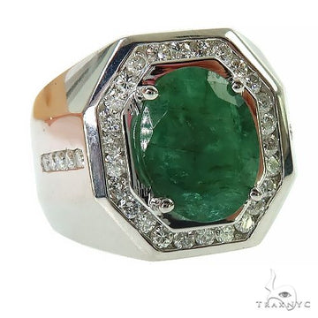 Men's silver ring with large emerald center and surrounding small clear gemstones.
