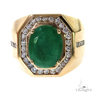 Yellow gold men's ring with oval emerald center surrounded by small diamonds.