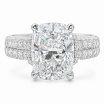 White gold engagement ring with cushion-cut diamond and triple pavé diamond band.
