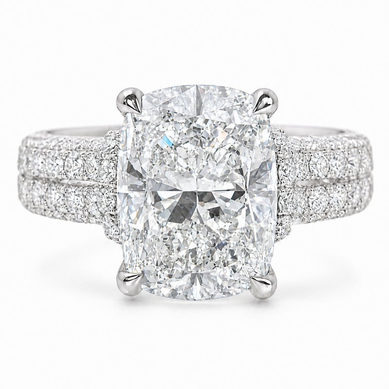 White gold engagement ring with cushion-cut diamond and triple pavé diamond band.