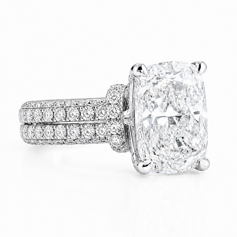White gold engagement ring with large cushion-cut diamond and double pavé band.