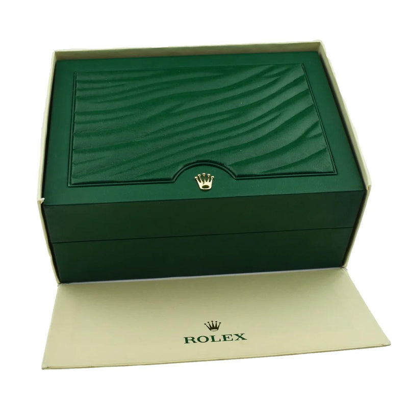 Green textured leather Rolex box with gold crown emblem and cream Rolex branded card below.