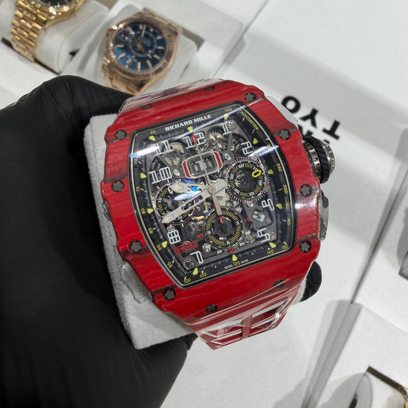 Richard Mille RM 11-03 in bright red NTPT carbon with a tonneau-shaped case and distinctive layered marbled pattern.

