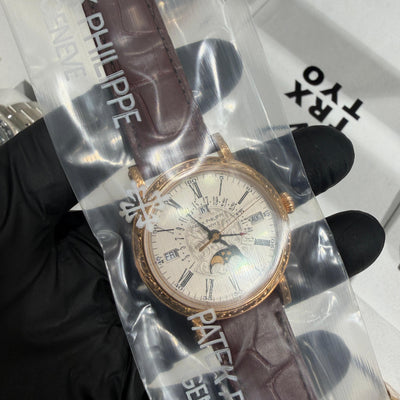Patek Philippe 5160R in 18K rose gold with a silvered dial, Roman numerals, and perpetual calendar moonphase display.


