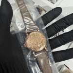 Hand-engraved rose gold caseback with detailed floral and arabesque patterns showcasing artisanal craftsmanship.

