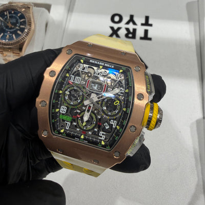 Richard Mille RM 11-03 rose gold watch with skeleton flyback chronograph dial and yellow crown.