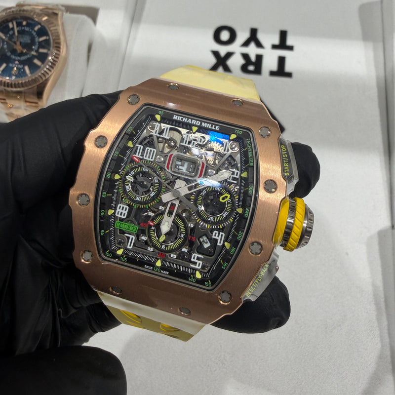 Richard Mille RM 11-03 rose gold watch with skeleton flyback chronograph dial and yellow crown.