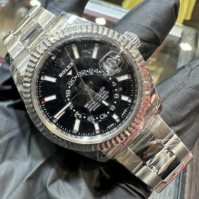 Rolex Sky-Dweller 42mm Oystersteel watch with black dial and fluted bezel on metal bracelet.
