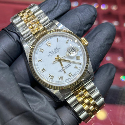 Rolex DateJust 36mm two tone gold and steel bracelet with white Roman numeral dial and date window.