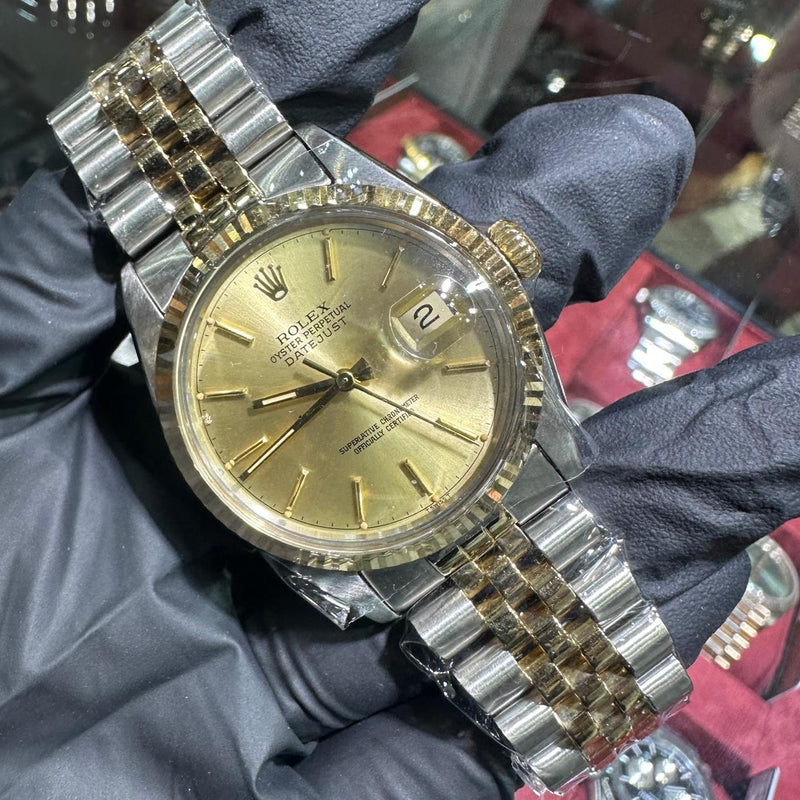 Rolex DateJust 36mm two tone yellow gold watch with champagne stick dial and jubilee bracelet.
