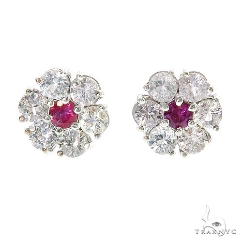 Cluster flower earrings with central red sapphire surrounded by clear gemstones, white metal setting