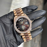 Rolex Day-Date 40mm 18K Everose Gold watch with diamond bezel and black dial on gold bracelet.