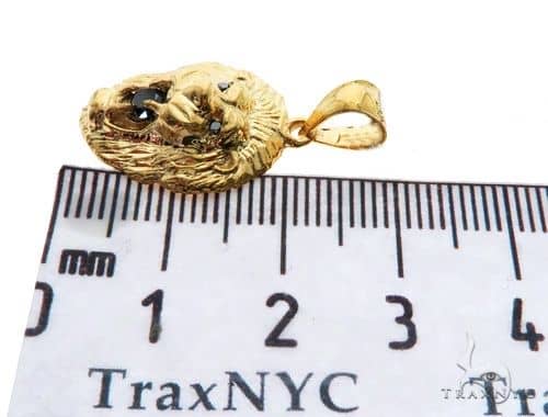 Yellow gold lion head pendant with black diamond eyes and detailed mane design.