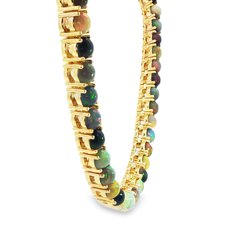 Gold chain necklace with round black opal gemstones evenly spaced around the links.