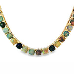 Gold chain necklace with round black opal gemstones evenly spaced around the links.