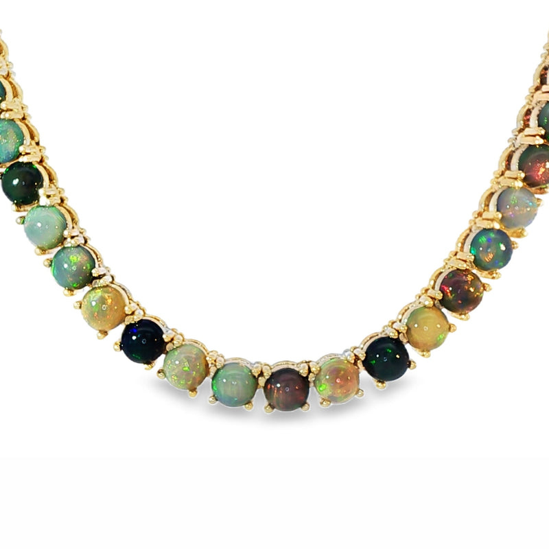 Gold chain necklace with round black opal gemstones evenly spaced around the links.