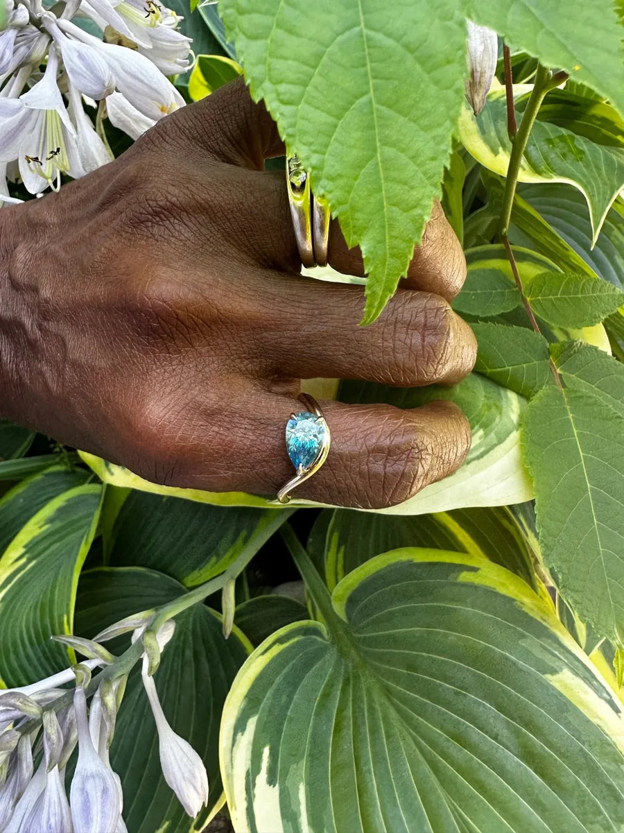 Pear twist ring, custom blue stone in yellow gold, worn by Pamela W.