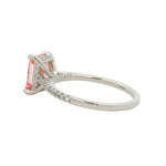White gold engagement ring with rectangular pink diamond and small diamonds on band.