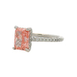 White gold engagement ring with rectangular pink diamond and small diamonds on band.