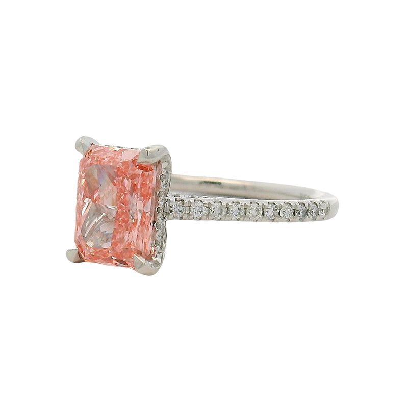 White gold engagement ring with rectangular pink diamond and small diamonds on band.