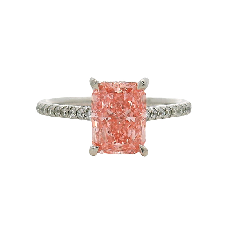 White gold engagement ring with rectangular pink diamond and small diamonds on band.