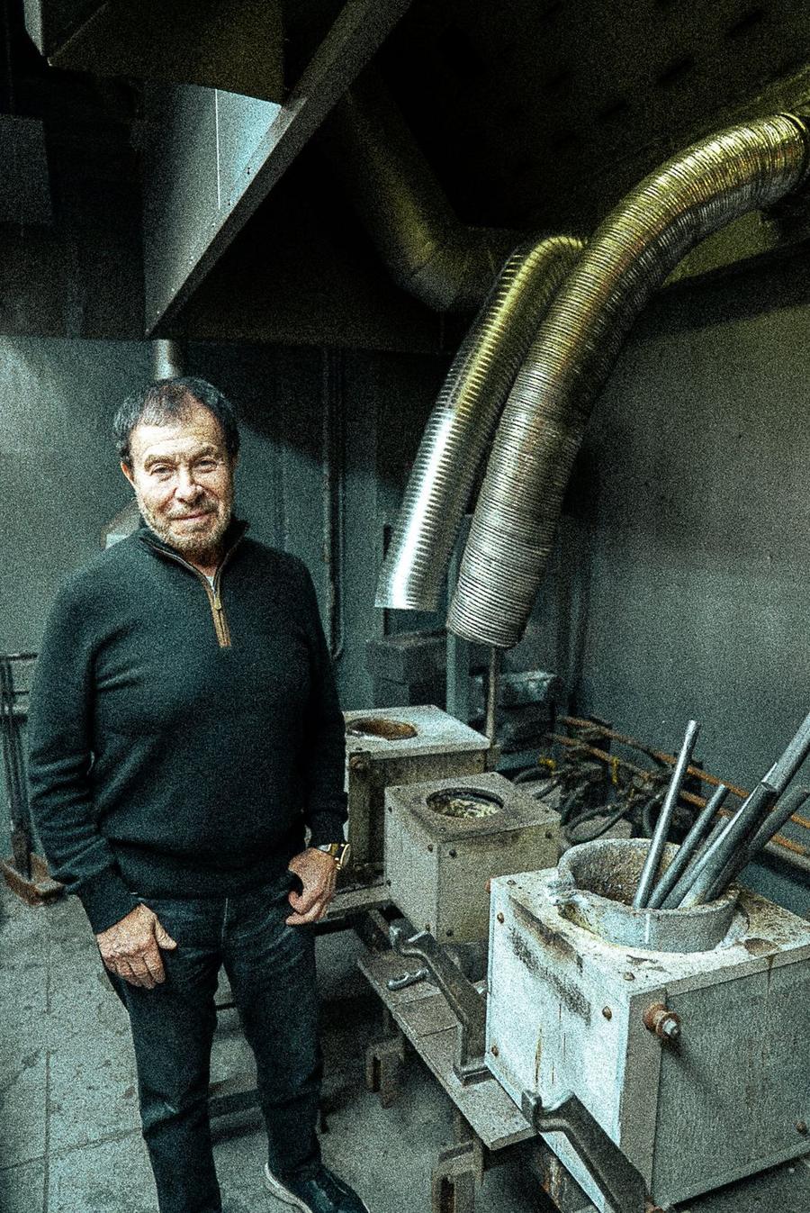 Michael beside his melting furnaces under silver exhaust ducts